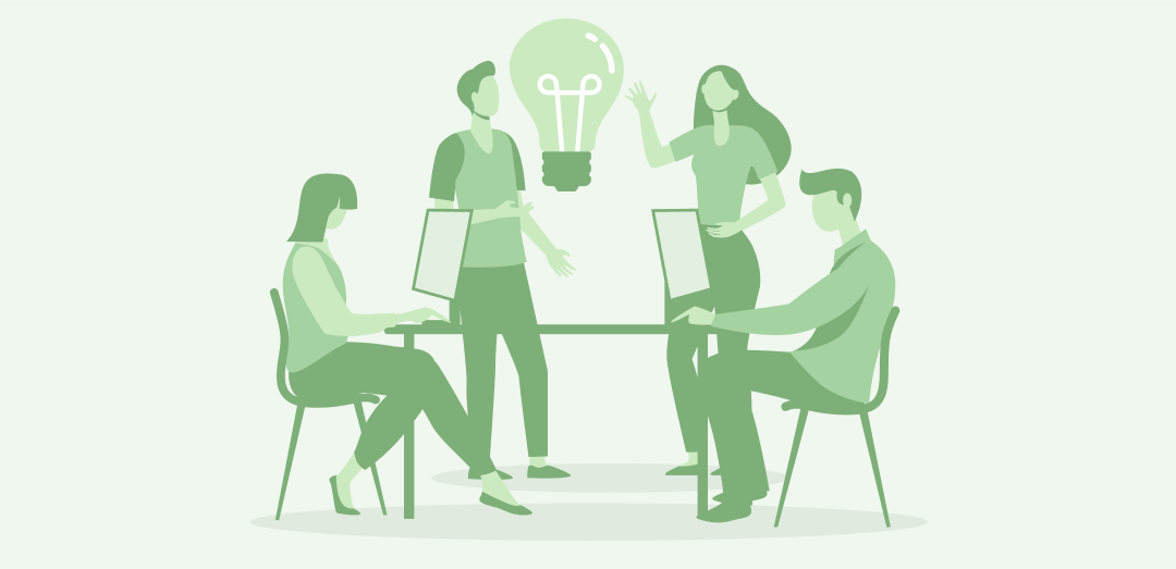 Cztery osoby pracują przy komputerach i omawiają pomysł